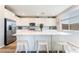 Modern kitchen featuring stainless steel appliances, a large island with bar stools, and sleek white cabinetry at 23 Strada Barbera, Henderson, NV 89011
