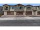 View of townhome exteriors each with a private garage, manicured landscaping, and neutral color scheme at 236 Callen Falls Ave # 1211, Henderson, NV 89011