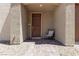 Cozy covered front porch with a cushioned chair and a decorative front door at 236 Callen Falls Ave # 1211, Henderson, NV 89011