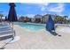 Community pool with lounge chairs and umbrellas under a sunny sky at 236 Callen Falls Ave # 1211, Henderson, NV 89011