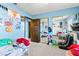 Bright bedroom with blue walls, carpet flooring, mirrored closet and playful decor at 2426 La Pluma St, Henderson, NV 89014