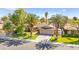 Charming single-story home with a well-manicured lawn, mature trees, and a two-car garage at 2426 La Pluma St, Henderson, NV 89014