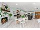 Bright kitchen features white cabinetry, stainless appliances, a stone fireplace, and an adjacent dining area at 2426 La Pluma St, Henderson, NV 89014