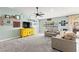 Comfortable living room with plush carpet and a bright yellow media center beneath the television at 2426 La Pluma St, Henderson, NV 89014