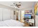 Bright bedroom with a ceiling fan, closet, and tv, plus access to an ensuite bathroom at 2460 Old Forge Ln # 48, Las Vegas, NV 89121