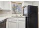 Kitchen area features stainless steel sink, white cabinets, quartz countertops, and black refrigerator at 2460 Old Forge Ln # 48, Las Vegas, NV 89121