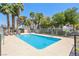 Community pool with lounge chairs, mature trees, and privacy fence at 2460 Old Forge Ln # 48, Las Vegas, NV 89121