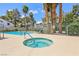 Community pool with jacuzzi, lounge chairs, mature trees, and privacy fence at 2460 Old Forge Ln # 48, Las Vegas, NV 89121