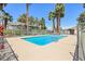 Community pool area featuring lounge chairs, mature trees, and privacy fence at 2460 Old Forge Ln # 48, Las Vegas, NV 89121