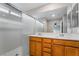 Bright bathroom featuring double sinks, a large mirror, and a shower with sliding glass doors at 2871 Tanager Hill St, Henderson, NV 89044