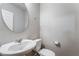 Powder room featuring a pedestal sink, a round mirror, and a toilet at 2871 Tanager Hill St, Henderson, NV 89044