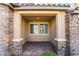 Covered front porch featuring stone pillars and a tiled floor at 2871 Tanager Hill St, Henderson, NV 89044