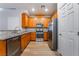 Well-lit kitchen featuring stainless steel appliances, granite countertops, and light wood-look flooring at 2871 Tanager Hill St, Henderson, NV 89044