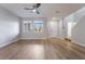 Open-concept living room with ceiling fan, wood-look floors, and staircase access at 2871 Tanager Hill St, Henderson, NV 89044
