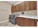 Well-lit laundry room with a front-loading washer and dryer, and ample counter space for folding and organizing laundry at 2901 Josephine Dr, Henderson, NV 89044