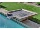 Close-up of a modern water feature spilling into a pristine pool, complemented by lush landscaping at 2901 Josephine Dr, Henderson, NV 89044