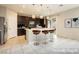 This is an open concept kitchen featuring a center island with bar stool seating, dark cabinets, and tile floors at 3163 Biccari Ave, Henderson, NV 89044