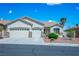 Front exterior view of a home with a two-car garage and manicured desert landscaping at 3278 Turning Bridge St, Las Vegas, NV 89135