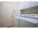 Well-organized laundry room with washer, dryer, storage cabinets, and convenient access to the exterior at 3278 Turning Bridge St, Las Vegas, NV 89135