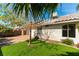 A well-maintained backyard with artificial grass, mature landscaping, and stucco wall at 3510 Judah Way, Las Vegas, NV 89147