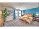 Bright bedroom featuring a large bed, blue accent wall, neutral carpeting, and decor at 5011 Sage Mesa Ave # Lot 143, Las Vegas, NV 89139