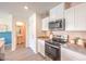 Modern kitchen features stainless steel appliances and breakfast bar; view of the powder room at 5011 Sage Mesa Ave # Lot 143, Las Vegas, NV 89139