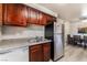 Compact kitchen featuring stainless steel appliances, wooden cabinets, and views of the dining area at 5020 Indian River Dr # 424, Las Vegas, NV 89103
