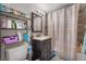 A bathroom with a vanity, mirror, shower with curtain, and open shelving at 5112 Pebble Beach Blvd, Las Vegas, NV 89108