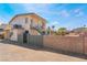 A two-story home's exterior is showcased, with a stairwell leading to the upper level and a block wall at 5112 Pebble Beach Blvd, Las Vegas, NV 89108