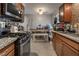 Compact kitchen with stainless steel appliances, granite countertops, and a dining area at 5112 Pebble Beach Blvd, Las Vegas, NV 89108