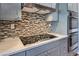 Modern kitchen featuring stainless steel appliances, mosaic tile backsplash, and gray cabinets at 5700 E Carter Ln, Pahrump, NV 89061