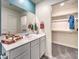 Bathroom showcasing a sleek vanity, large mirror, and adjacent walk-in closet with shelving at 6104 Aster Garden St # 129, North Las Vegas, NV 89081