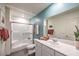 Stylish bathroom featuring a glass-enclosed shower, single sink vanity, and blue accent wall at 6104 Aster Garden St # 129, North Las Vegas, NV 89081