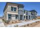 Modern two-story townhome with a neutral exterior, walkway, and small decorative shrubs at 6104 Aster Garden St # 129, North Las Vegas, NV 89081