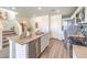 Modern kitchen featuring stainless steel appliances, an island with sink, and gray wood flooring at 6104 Aster Garden St # 129, North Las Vegas, NV 89081