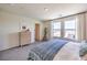 Bright main bedroom with large windows, neutral tones, and minimalist decor with wood furnishings at 6104 Aster Garden St # 129, North Las Vegas, NV 89081
