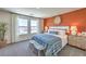 Stylish main bedroom featuring an accent wall, comfortable bed, and plenty of natural light at 6104 Aster Garden St # 129, North Las Vegas, NV 89081