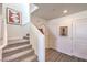 Clean stairway with gray carpeted steps, white walls, and modern decorative art at 6104 Aster Garden St # 129, North Las Vegas, NV 89081