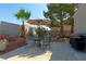 An outdoor seating area with grill, table, chairs, and mature trees at 614 Ravenglen Dr, Las Vegas, NV 89123