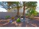Backyard featuring mature trees, desert landscaping, and private patio space at 614 Ravenglen Dr, Las Vegas, NV 89123