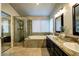 Luxurious bathroom with a soaking tub, separate shower, and granite countertops with double sinks at 614 Ravenglen Dr, Las Vegas, NV 89123