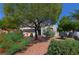 Lovely two-story home featuring mature trees and colorful flowering bushes in the front yard at 614 Ravenglen Dr, Las Vegas, NV 89123