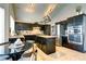 Contemporary kitchen with black cabinetry, stainless steel appliances, and a central island with stone countertops at 614 Ravenglen Dr, Las Vegas, NV 89123