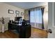 Home office with dark wood desk, a large window with blinds, and wood flooring at 614 Ravenglen Dr, Las Vegas, NV 89123