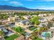 An aerial perspective of the property, highlighting its pool, landscaping, and solar panels against a mountain backdrop at 6335 Iginlas Goal Ave, Las Vegas, NV 89131