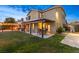 Spacious backyard featuring a covered patio with outdoor seating, a fire pit, and lush green grass at 6335 Iginlas Goal Ave, Las Vegas, NV 89131