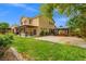 Large landscaped backyard with manicured lawn, mature trees, garden area, gazebo, and patio with house view at 6335 Iginlas Goal Ave, Las Vegas, NV 89131