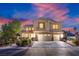 Beautiful two-story home featuring a three-car garage and meticulously manicured landscaping at sunset at 6335 Iginlas Goal Ave, Las Vegas, NV 89131