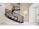 Grand foyer with a curved staircase featuring wrought iron railings and neutral carpeting at 6335 Iginlas Goal Ave, Las Vegas, NV 89131