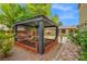 A backyard metal gazebo sits on a bed of gravel, near a garden with red brick border at 6335 Iginlas Goal Ave, Las Vegas, NV 89131